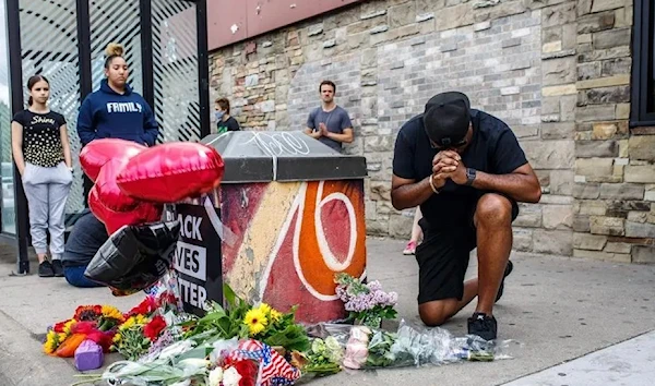 A protester prays in front of the memorial of George Floyd in 2020 (AFP via Getty Images)