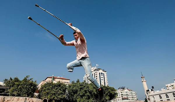 Mohamed Aliwa, a Palestinian youth whose leg was amputated near the knee in 2018 after he was shot by Israeli occupation forces, shows off his parkour skills despite his disability in Gaza City, Jan. 4, 2021. (AFP)