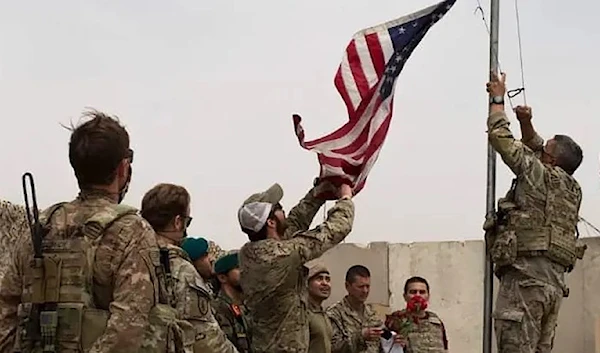 US soldiers lowering the US national flag during a handover ceremony to the Afghan National Army in Helmand province, May 2, 2021. (AFP)