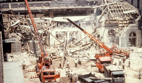 In this file photo taken on Aug. 2, 1980, cranes remove debris after a powerful bomb blasted the train station of Bologna, Italy (AP Photo)