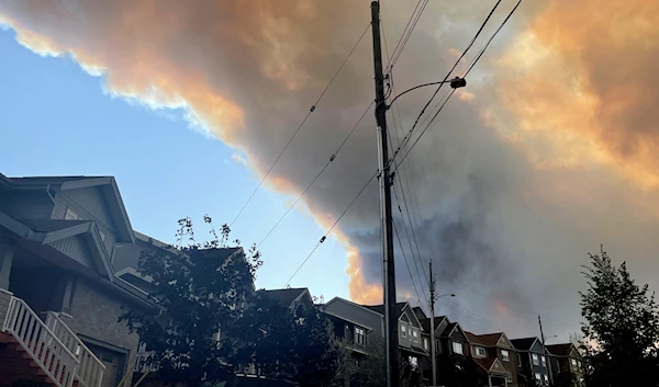 Smoke from the Tantallon wildfire rises over houses in nearby Bedford, Nova Scotia, Canada, May 28, 2023. (Reuters)