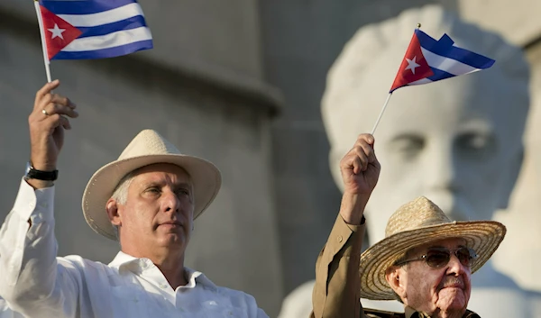 Cuba's President Miguel Diaz-Canel (L) and former Cuban President Raul Castro wave Cuban flags as they watch the annual May Day parade file past at Revolution Square in Havana, Cuba, May 1, 2019. (AP)