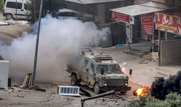 An explosive device detonates next to an Israeli armoured vehicle after the Israeli occupation forces raided Jenin in the occupied West Bank, Palestine, June 19 2023. (AFP)