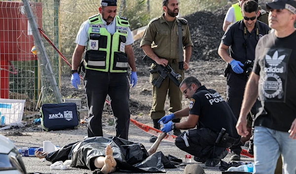 Occupation police and forensics experts inspect a dead body at the site of shooting carried out by Palestinian Fida'is near the settlement of 'Eli', occupied West Bank, Palestine, June 20 2023. (AFP)