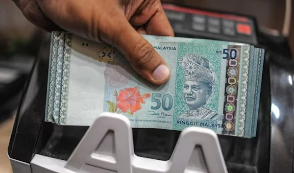 A money changer counting Malaysian ringgit banknotes. (AFP)