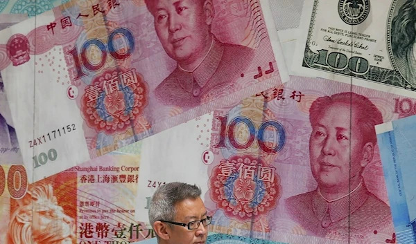 In this Tuesday, Aug. 6, 2019, photo, a man walks by a money exchange shop decorated with Chinese yuan banknotes and other countries currency banknotes at Central, a business district in Hong Kong. (AP)