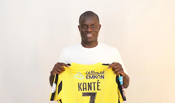 N'Golo Kante poses for a photo as he displays the back of an Al-Ittihad jersey after singing for the club, 21 June 2023. (@ittihad_en/Twitter)