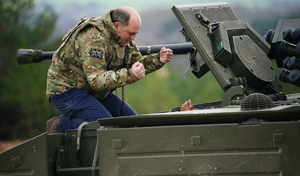 Ben Wallace is given a demonstration of an Ajax Ares Armoured Fighting Vehicle, by the crew on the training range at Bovington Camp, in England, on February 22 (AFP)