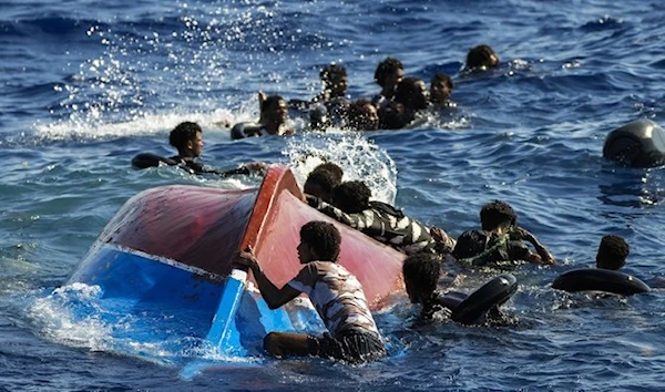 Migrants swim next to their overturned wooden boat during a rescue operation by Spanish NGO Open Arms at south of the Italian Lampedusa island at the Mediterranean sea, Thursday, August 11, 2022. (AP)