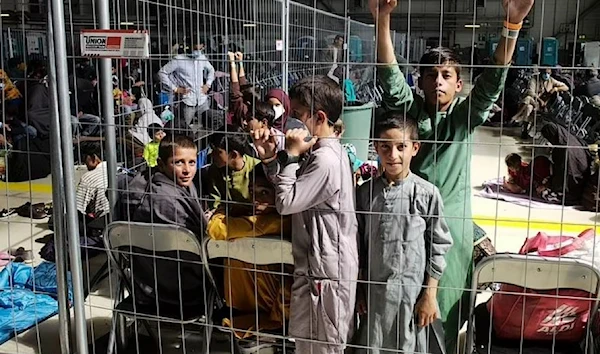 Children and other Afghan refugees wait inside a makeshift departure gate inside a hangar at Ramstein Air Base. (AP)