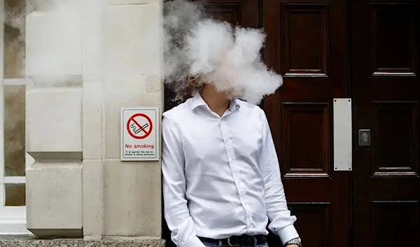 A young man vaping on the street (AFP via Getty Images)