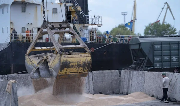 Workers load grain at a grain port in Izmail, Ukraine, on April 26, 2023. (AP)