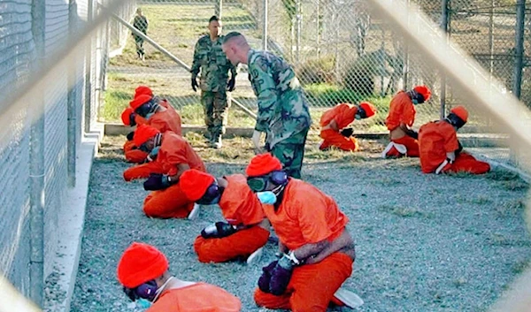 Detainees sit in a holding area at the US Navy base at Guantanamo Bay, Cuba, during in-processing to the temporary detention facility on Jan. 11, 2002. (AP)