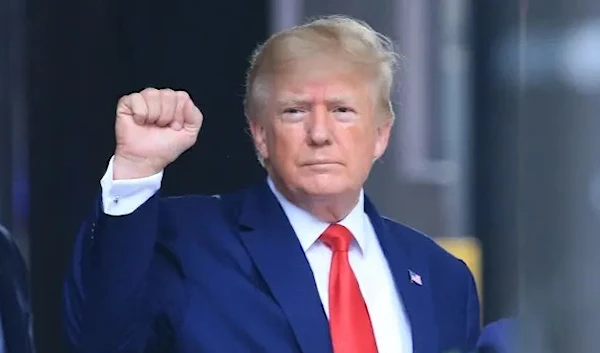 Former US President Donald Trump raises his fist while walking to a vehicle outside of Trump Tower in New York City on August 10, 2022. (AFP)