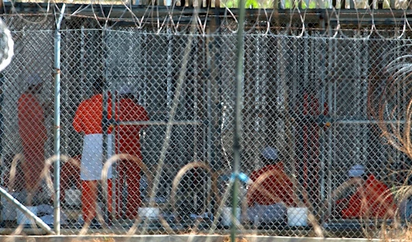 Detainees rom Afghanistan sit in their cells at Camp X-Ray at the US Naval Base in Guantanamo Bay, Cuba, February 2 2002. (AP)