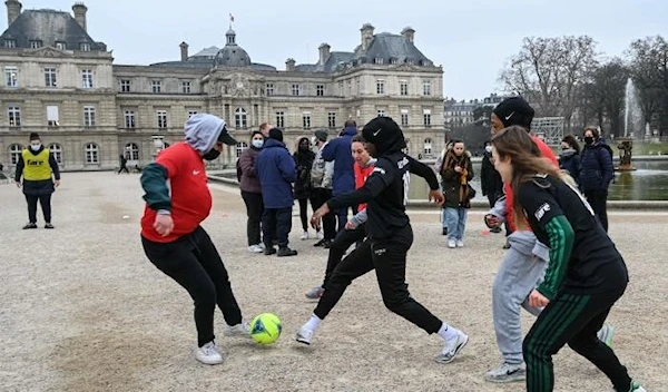 The Hijabeuses play football in front of the Sénat in Paris on January 26, 2022 as a protest after senators voted in favor of a ban on the wearing of religious symbols during events and competitions organized by sports federations. (AFP)