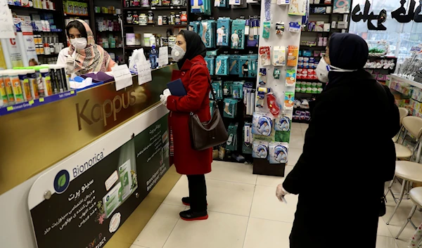 Customers wait as a pharmacist prepares medicines, in Tehran, Iran, February 29, 2020 (AP)