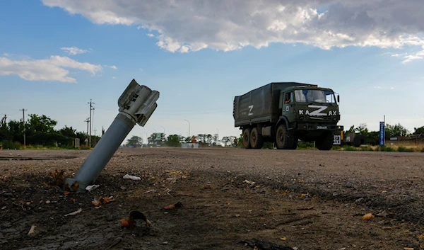 A Russian military truck drives close by an unexploded rocket in the village f Chornobaivka, Russia, July 26 2022. (Reuters)