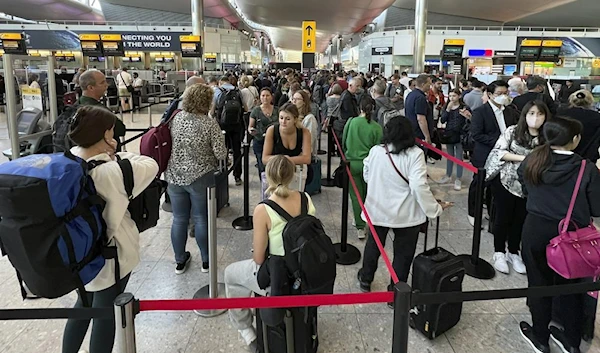 Travellers queue at security at Heathrow Airport in London, Wednesday, June 22, 2022. (AFP)