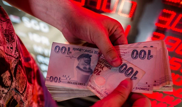 A money exchanger counts Turkish lira banknotes at a currency exchange office in Istanbul, Turkey, Aug. 8, 2018 (AFP Photo)