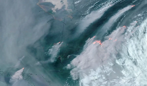 In this GOES-16 GeoColor and fire temperature satellite image taken Tuesday, June 6, 2023 at 640 p.m. EDT and provided by CIRA/NOAA, smoke from wildfires burning in the Canadian Provinces of Quebec, and Ontario, drift southward. (CIRA/NOAA via AP)