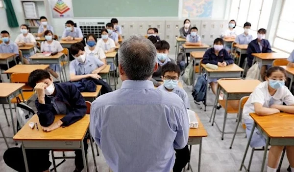 A teacher introduces himself to students on the first day of the new term at a secondary school in Hong Kong on Sept 1, 2021. (Reuters)