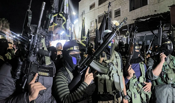 Resistance fighters of the Al-Quds Brigades march alongside their comrades from the Al-Aqsa Martyrs' Brigades and Al-Qassam Brigades through the Jenin camp, occupied West Bank, Palestine, August 18 2021. (AFP)