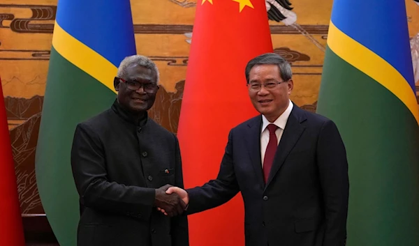 Solomon Islands' Prime Minister Manasseh Sogavare hakes hands with China's Premier Li Qiang after signing a number of agreements at the Great Hall of the People in Beijing, China, July 10 2023. (AFP)