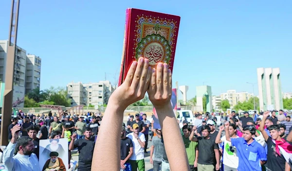 Supporters of the Shiite cleric Muqtada al-Sadr raises of the Quran, the Muslims' holy book, during a demonstration in front of the Swedish embassy in Baghdad in response to the burning of Quran in Sweden, Baghdad, Iraq, Friday, June 30, 2023. (AP)