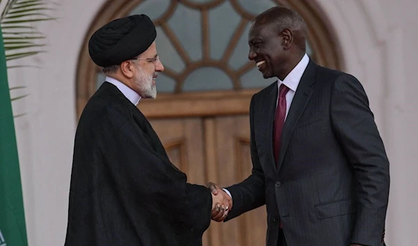 Iranian President Ebrahim Raisi shakes hands with Kenyan President William Ruto after a press conference at the State House in Nairobi on July 12, 2023 (AFP)