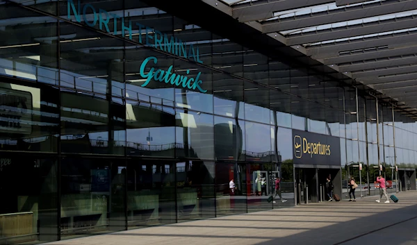 Passengers walk into the Departures entrance at the North Terminal of Gatwick Airport near Crawley, just south of London, July 22, 2020 (AP)