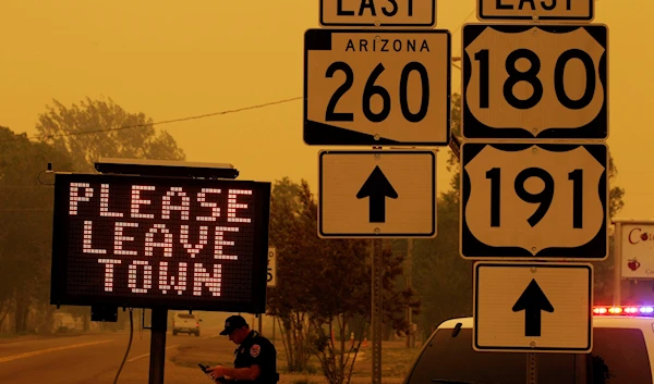 A sign asks for residents to evacuate as the Wallow Fire approaches in Springerville, Ariz., Wednesday, June 8, 2011. (AP)