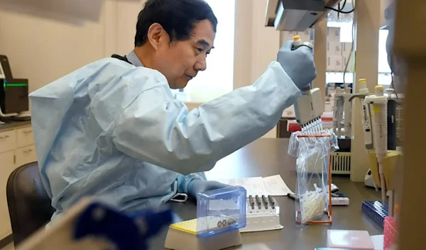 In this Monday, March 2, 2020, file photo, microbiologist Xiugen Zhang runs a Polymerase Chain Reaction, or PCR, test at the Connecticut State Public Health Laboratory, in Rocky Hill, Conn. (AP Photo/Jessica Hill, File)