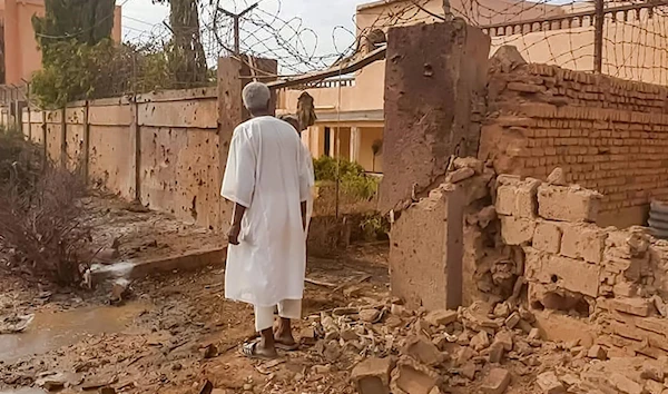 A man walks through rubble in the aftermath of clashes and bombardment in the Ombada suburb on the western outskirts of Omdurman on 4 July 2023 (AFP)