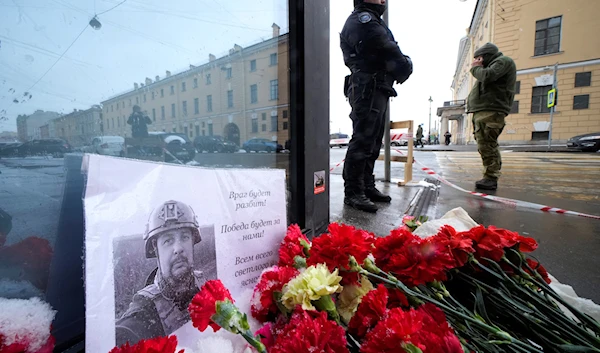 Flowers and a poster with a photo of blogger Vladlen Tatarsky placed near the site of an explosion at the "Street Bar" cafe in St. Petersburg, Russia, April 3, 2023 (AP)