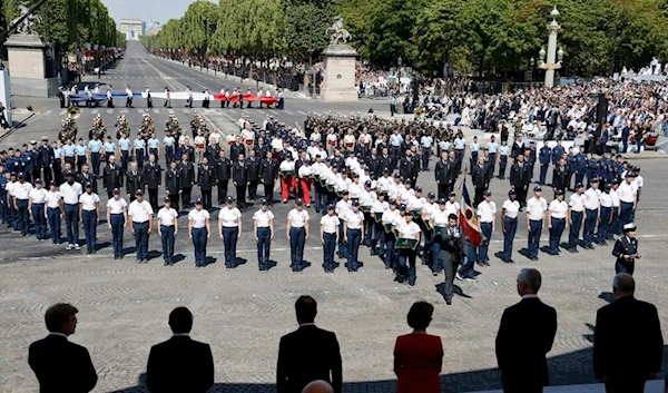 Officials enjoy the annual Bastille Day military parade on the Champs-Elysees avenue in Paris. (AFP)