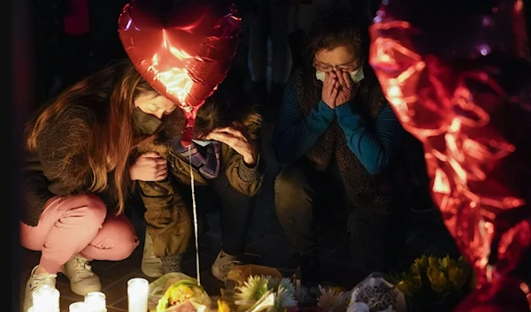 Mourners pause at a memorial vigil honoring the victims of a shooting at the Star Ballroom Dance on Monday 23, 2023. (AP)