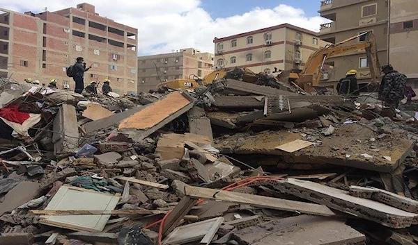 Emergency workers sift through the rubble of a collapsed apartment building, in Cairo, Egypt,  March 27, 2021 (AP)