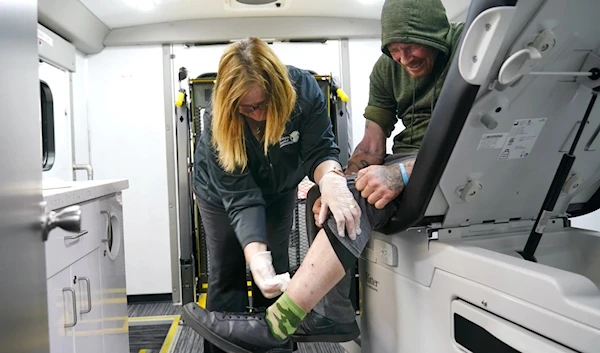 Registered nurse Kathy Lalli treats a man's xylazine-associated leg injuries at the Kensington Hospital wound care outreach van in Philadelphia on May 23. (AP)