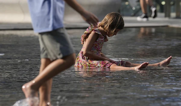 Children cool off in a public fountain in Milan, Italy, on July 15, 2023. (AP)