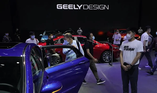 FILE - Visitors look at cars produced by Geely at the Auto China 2020 show in Beijing on Sept. 27, 2020 (AP)