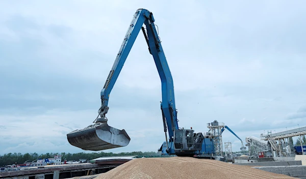 An excavator loads grain into a cargo ship at a grain port in Izmail, Ukraine, on April 26, 2023. (AP)