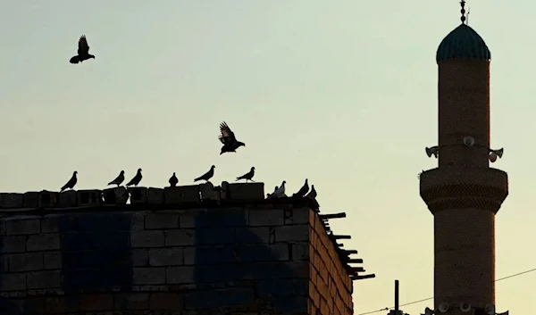 Birds fly near the minaret of a mosque in Basra on March 22, 2023 ahead of the Muslim fasting month of Ramadan. (AFP)