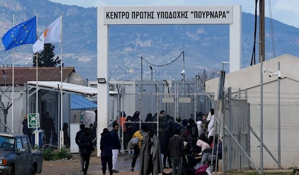 Migrants stand outside of Pournara migrant reception center in Kokkinotrimithia outside of the capital Nicosia, Cyprus, on Wednesday, Feb. 9, 2022. (AP)