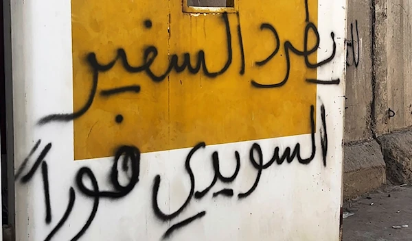 Writing on the walls saying ""Expel the Swedish ambassador immediately," is seen as hundreds stand outside the Swedish embassy in Baghdad, Iraq, Thursday, June 29, 2023, in protest of the burning of a Quran in Sweden.  (AP)