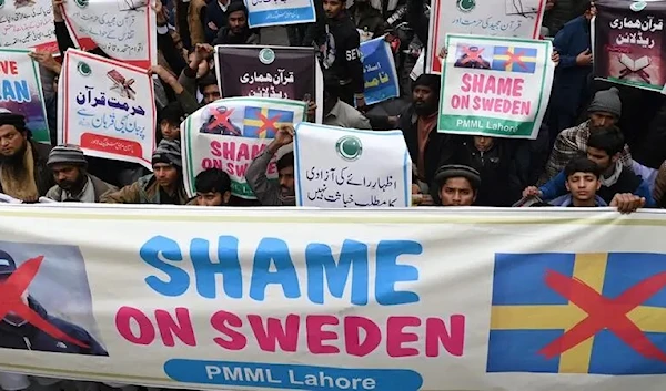 Demonstrators carry placards during a protest against the burning of the Quran in Sweden, in Lahore on January 24, 2023. (AFP)