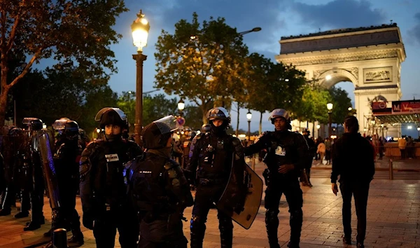 Police officers patrol in front of the Arc de Triomphe on the Champs Elysees in Paris, Saturday, July 1, 2023 (AP Photo/Christophe Ena)