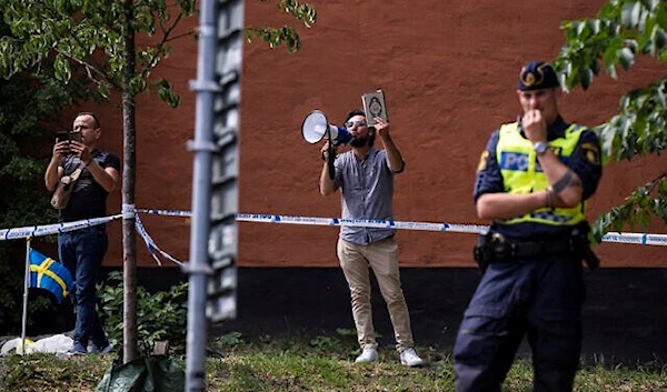 Salwan Momika holds a Quran as he protests outside a mosque in Stockholm on June 28, 2023 (AFP)