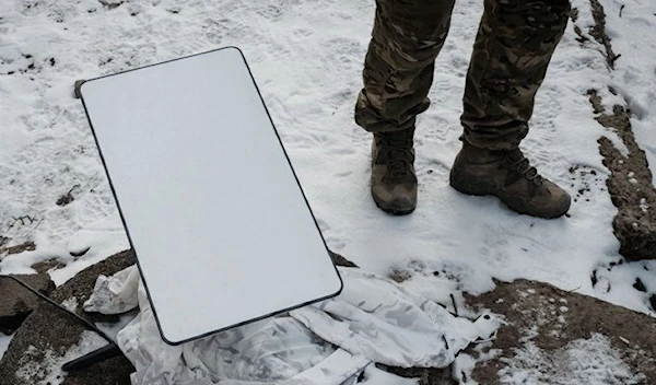 A Ukrainian serviceman stands next to the antenna of the Starlink satellite-based broadband system in Bakhmut on February 9, 2023. (AFP)