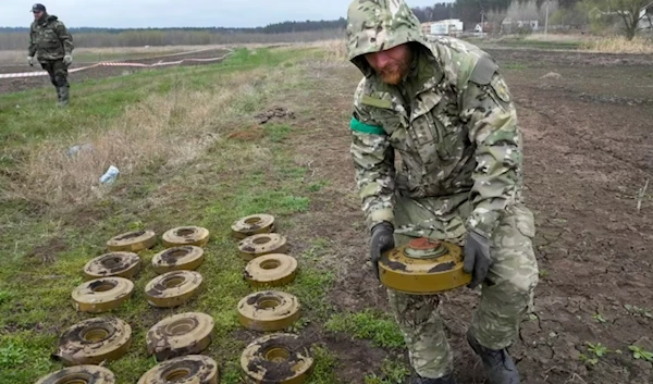 An interior ministry sapper collects mines on a mine field after recent battles in Irpin close to Kyiv, Ukraine, April 19, 2022. (AP)